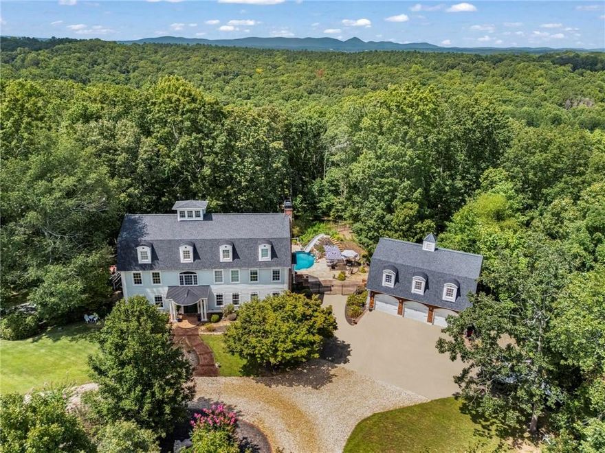 PRICE REDUCTION + MOTIVATED SELLER!
Seller is relocating for work and has reduced the price to make this incredible property one of the best values on the market. Now priced below fair market value!
“Timeless Luxury with Modern Indulgence”
Welcome to a rare opportunity to own one of Ball Ground’s most distinctive estates, an extraordinary Cape Cod-style residence set on 3.76 private acres at the end of a quiet, wooded lane. Just minutes from the charm of downtown Ball Ground, and less than an hour from both Atlanta and the Blue Ridge Mountains, this home offers the perfect balance of retreat and accessibility.
Crowned with a widow’s tower, the home’s striking architectural profile immediately sets it apart. Inside, over 9,000 square feet of refined living unfolds across 8 bedrooms and 6.5 baths, crafted with timeless old-world detail and modern convenience.
Highlights include:
Heated Saltwater Pool Retreat – Travertine decking, fountains, and wooded/seasonal Mountain views frame a custom-built pool with slide and outdoor shower.
Grand In-Law Quarters – A private 3-bedroom suite with its own entrance, driveway, kitchen, dining room, living spaces, laundry, and marble bath. Perfect for multigenerational living or long-term guests.
Entertainment at Its Finest – A split-level theater room designed for cinematic immersion, plus expansive wraparound porch, fireplaces, and outdoor gathering spaces.
Expansive Grounds – Trails, fruit trees, berry bushes, and even a private shooting range create a lifestyle as active as it is serene.
Chef’s Domain – Wolf induction oven with hood and pasta arm, dual dishwashers, multiple pantries, and over 2.5 kitchens for culinary flexibility.
Superior Craftsmanship – Real hardwood and marble floors, wainscoting, Crawford ceilings, clawfoot tub, and custom mantles throughout.
Additional Touches – Tesla charger, full workshop, studio space, hardwired security and fire system, and a spiral staircase to the widow’s peak with breathtaking views.
The primary suite offers a true retreat with two walk-in closets, a full dressing room, and a spa-inspired bath.
Designed for multigenerational living, entertaining, and private retreat alike, this estate blends Cape Cod elegance with the comforts of modern luxury. It is not just a home, but a landmark property, Ball Ground’s true diamond.