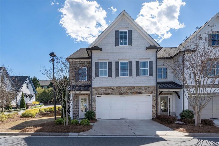 Nestled in a prime location just steps from Marietta Square and the Historic Kennesaw Mountain Park, this stunning end-unit, former model home boasts exceptional craftsmanship and timeless elegance. The four-side brick exterior with stacked stone accents exudes curb appeal, while the thoughtfully designed interior showcases high-end finishes and modern comforts. Inside, an inviting open floor plan is highlighted by abundant natural light, shiplap detailing, hardwood floors, and exquisite light fixtures throughout. The gourmet kitchen features a wood accented island and vent hood, two pantries, quartz countertops, stainless steel appliances, subway tile backsplash, a wine bar, soft-close cabinets—including lighted upper cabinets—and stylish pendant lighting. The great room is a showstopper, complete with floating shelves, built-in cabinetry, a gas stone fireplace, and dual doors leading to a private brick patio with an outdoor brick fireplace.The oversized primary suite offers a true retreat, featuring a spacious custom walk-in closet and a private balcony with serene greenery views. The spa-like primary bathroom is appointed with dual sinks, a soaking tub, a large walk-in shower, and tile flooring. The guestrooms have access to their own beautifully tiled full bathroom. The third-floor in-law suite provides incredible versatility, offering a kitchen, dining area, bedroom, bathroom, closet, living room, and ample storage. Additional highlights include a convenient drop zone in the foyer, a laundry room with a sink, cabinets, and a folding station, an irrigation system as well as zoned heating and air with multiple thermostats.  Community amenities include an onsite restaurant, and the home is just minutes from top-ranked schools, and major interstates.  This home perfectly blends luxury, comfort, and convenience.
