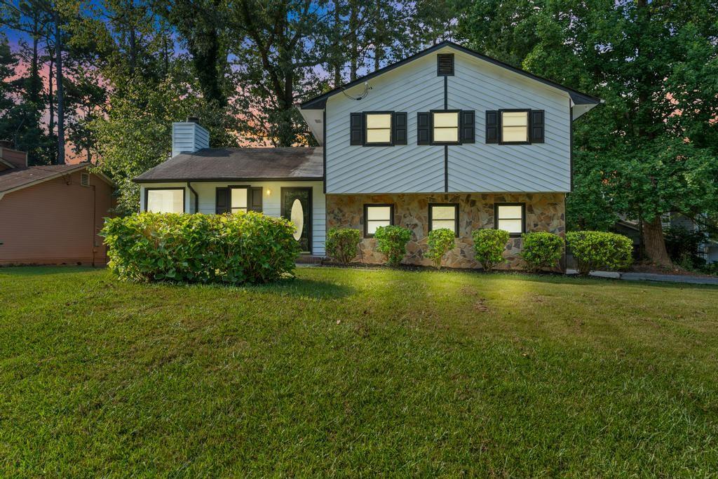 Welcome to this beautifully renovated split-level home on a spacious corner lot in Stone Mountain. Inside, you'll find a large open-concept living area filled with natural light, luxury flooring, and a modern tile fireplace with stylish chandeliers above. Just a few steps down, the updated kitchen features granite countertops, stainless steel appliances including a refrigerator, stove and oven combo, and dishwasher, along with an eat-in dining area. Off the kitchen is a versatile bonus room perfect for a home office, plus a half bath with access to the exterior. Another bonus space at the back of the home offers the perfect spot for a sitting room or hobby area. Upstairs, the oversized primary suite includes a beautifully tiled en-suite bath, and two additional bedrooms share a renovated hall bathroom. The fully fenced backyard includes a storage shed and offers plenty of space to relax or entertain. This home is move-in ready and full of charm, inside and out.