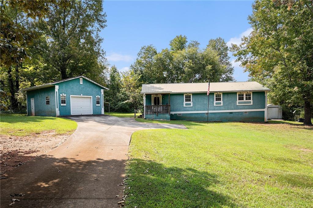 Seller to offer $5,000 towards CC. Selling AS IS!!!! Check out this beautiful home in the great Covington area. This home has a new water heater, new stove, new refrigerator, and fairly new metal roof. This home will also come with an extra lot that can be used to build on. As you enter the home there's an open concept living/dining room. Primary suite has large bedroom with a walk in closet being used for landry room. Primary bathroom granite counters and storage shelves. This home comes with a detached garage and a detached car port. It also comes with a seperate storage sheet for tools and lawn material. Enjoy your coffee/tea on a porch and large backyard with mature trees. Brand new electrical, HVAC, updated plumbing. Brand new insulation in the attic, free of termites, septic tank is in great working condition. Convenient highway access. The location offers easy access to an array of retailers, restaurants, entertainment, and much more.