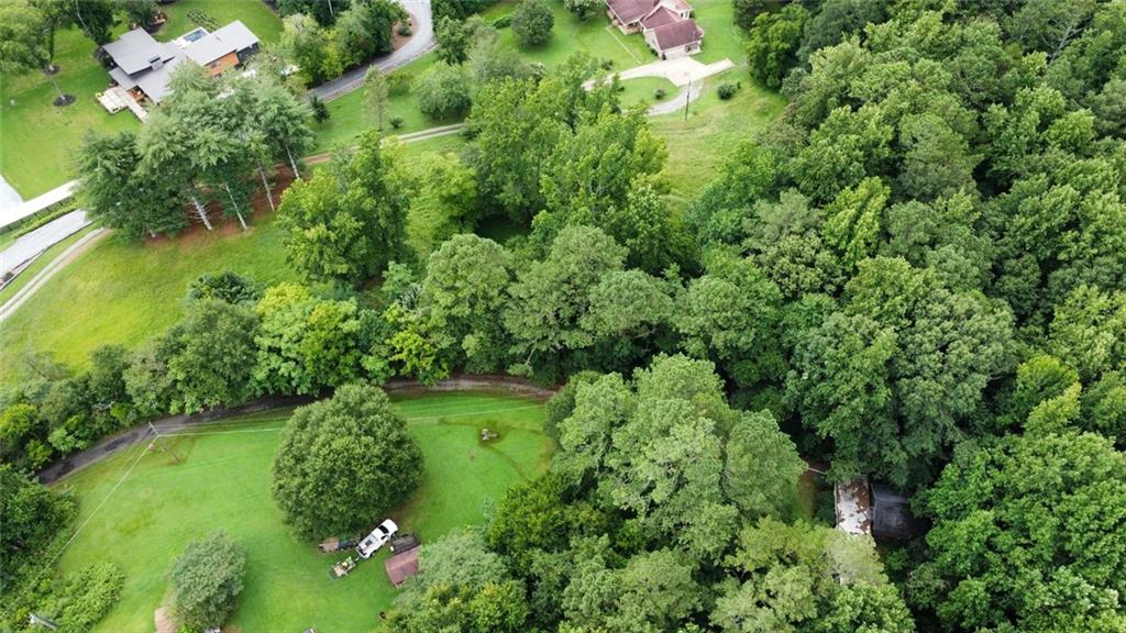 Discover the Charm of 2626 Hickory Road Holly Springs, GA Welcome to 2626 Hickory Road—a rare opportunity to own 4.96 acres of peaceful, scenic land in the heart of Canton, Georgia. Perfectly priced and unmatched in value, this property offers a blank canvas for your dream home or next development project. Located in the highly sought-after Sequoyah High School district, this location blends top-tier education with a strong sense of community, making it ideal for families. Nature lovers will appreciate the proximity to J.B. Owens Park, just steps away, featuring modern amenities and tranquil walking trails. Enjoy the perfect balance of serenity and convenience: just 2.7 miles from Downtown Holly Springs and the exciting upcoming Town Center, promising a vibrant mix of shops, dining, and entertainment. Everyday essentials are also within easy reach—Publix, Kroger, Starbucks, Hickory Flat, Bradshaw Farm Golf Club, and Alpha Equestrian Center are all within a 3-mile radius. Commuting is simple with nearby access to I-575, connecting you seamlessly to Cherokee County and the greater Atlanta area. The property already has electricity connected to Tract 2, and an existing mobile home on-site offers flexibility for temporary living or a construction base. Whether you're looking to build a private retreat or explore development potential, this is your chance to own land in one of Cherokee County's most desirable and fast-growing areas. Don't miss out—make 2626 Hickory Road the foundation for your next chapter. Also listed as mobile home (7627183)