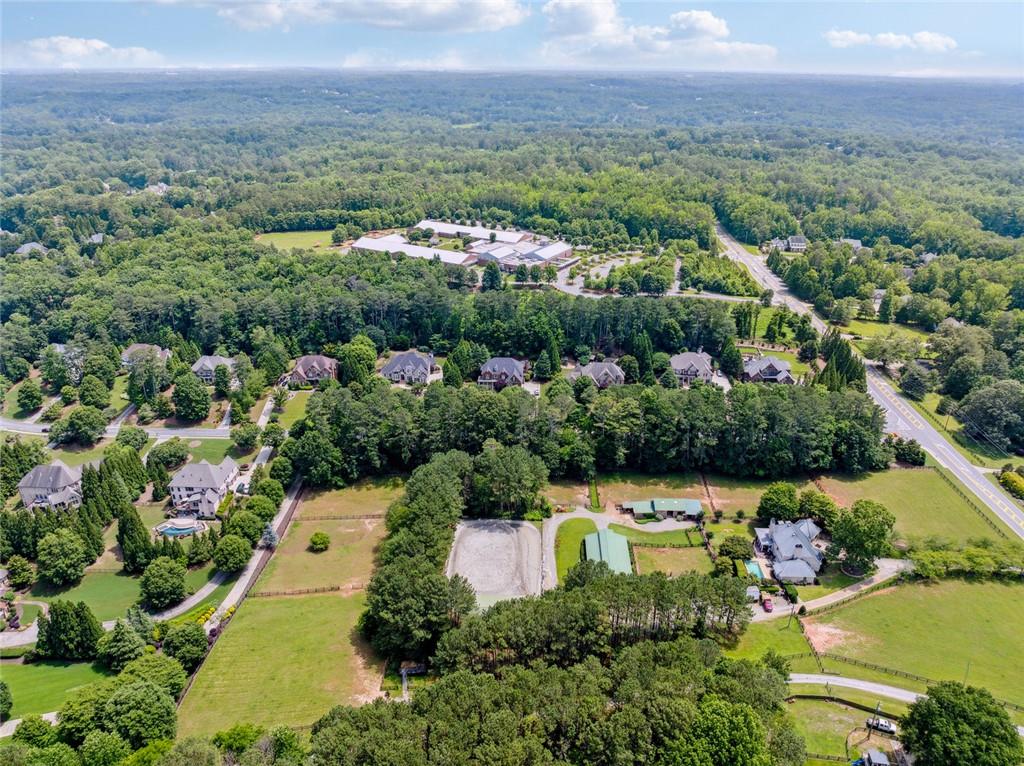 Rare opportunity for developing/rezoning potential allowing up to four homesites, or the chance to own a distinctive equestrian property with permitted equestrian use in the sought-after White Columns community. Spanning 5.26 acres, this premier parcel showcases top-tier equestrian amenities, including a 100’ x 50’ covered arena and a 150’ x 100’ outdoor arena with M10/river sand footing and a remotely controlled automatic watering and sprinkler system.
In total, the property features 12 stalls, with 8 full-sized (12’x12’) stalls located in the center aisle barn, each equipped with individual water access and an automatic fly spray system throughout. Complementing the main barn is a 4-stall exterior shed-row style barn. Additional amenities include a feed room, two tack rooms, dedicated grooming areas, a wash rack with hot and cold water, and an on-site washer and dryer.
Build your dream home in one of Milton’s most prestigious neighborhoods while enjoying immediate access to thoughtfully designed equestrian amenities. Whether you're a competitive rider or simply seeking a horse property close to downtown, this is an extraordinary canvas to create the estate you’ve envisioned.
White Columns is a premier gated neighborhood in Milton, Georgia. The community amenities include a championship-caliber Tom Fazio-designed 18-hole golf course, a 20,000-square-foot clubhouse with casual and fine dining, a golf pro shop and instruction center, a modern fitness center, a junior Olympic swimming pool and kids' pool, tennis courts, pickleball courts, a playground area, and a colonial-style Verandah Pool and Tennis Clubhouse. Residents enjoy a walkable, tree-lined setting, community events, and close proximity to top-rated schools, shopping, restaurants, and major highways—just minutes from downtown Alpharetta, Crabapple, and Avalon. Whether you’re seeking a luxury estate lot, premier equestrian facilities, or future development opportunity, this unique property within White Columns HOA offers unmatched potential.
SPECIAL NOTES:
This property was originally part of 15055 Birmingham Highway and has since had a parcel re-organizing by the current owners. GIS IS NOT UPDATED YET. Tract C, which is being offered for sale, consists of 5.26 acres as shown on the attached survey.
If the buyer removes the equestrian special-use designation, the property may be rezoned for residential development. Based on conversations with the City of Milton, the 5.26-acre parcel could potentially support up to four homes through the Major Subdivision process. In this scenario, all homes would be accessed directly from within White Columns, and the equestrian access requirement would no longer apply.
Under the current White Columns equestrian-permitted use, all equestrian traffic must enter from Birmingham Highway. If the buyer wishes to maintain the existing equestrian facilities, they may build a future residence with direct access from 604 Glenover Drive within White Columns, while barn and equestrian access will remain via Birmingham Highway. To support this, the seller will record an easement allowing continued access from Birmingham Highway to the barn.