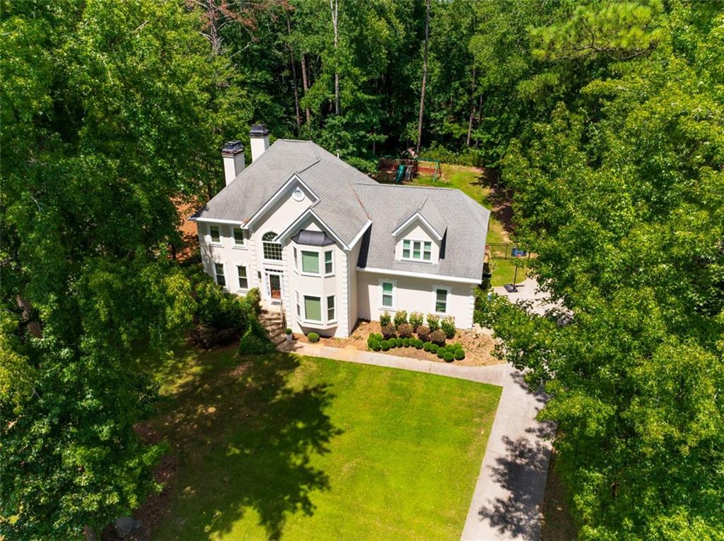 Welcome to another beautiful home, perfectly positioned in the highly sought-after Guilford Forest community. This spacious 4-bedroom, 3.5-bath residence offers a timeless floor plan with a partial unfinished basement, ready for your personal touch. On the main level, the room sizes are generous and offer separate gathering areas, ideal for entertaining or relaxing. The open morning room flows seamlessly into the screened-in sun porch, offering the perfect blend of indoor and outdoor living. Hardwood flooring and stair treads throughout the main level, wrought iron balusters, and a bright color palette that captures the natural light throughout the home create a warm and inviting atmosphere. Additional features include two fireplaces (one of which is double-sided, enhancing the owner bathroom), custom closets and pantry, skylights, and dual staircases with access from both the foyer and kitchen. The property is completed by a two-car garage with built-in storage space, a fully enclosed backyard with wrought iron fencing and pavers, and an electric awning that enhances the private outdoor patio area. Community features include a clubhouse, fitness center, playground, pool, and tennis courts, with convenient access to major interstates, the airport, downtown, and shopping.
