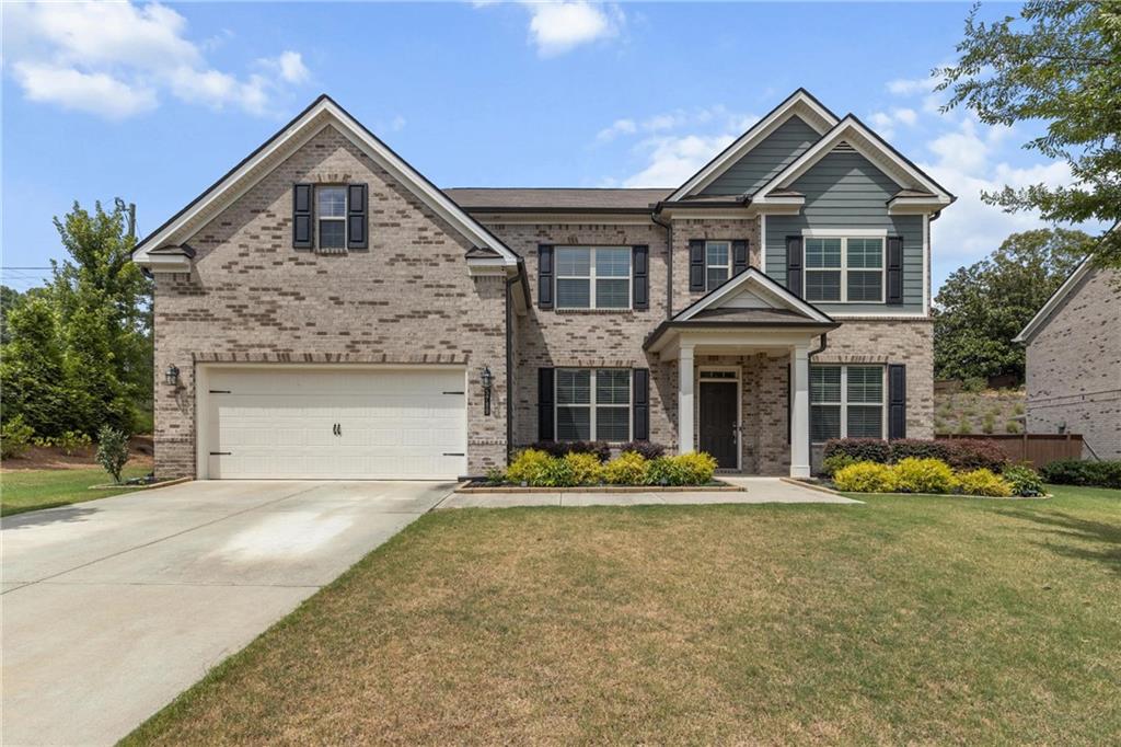 Welcome to this elegant three-sided brick home, ideally located in the highly sought-after North Gwinnett High School district. Situated on a beautifully level front yard with a striking brick façade, this residence offers curb appeal and comfort from the moment you arrive. Step through the front door into a spacious dining room and versatile flex room, perfect for a home office or formal sitting area. The living room features soaring coffered ceilings and a custom built-in bookshelf, creating an inviting space for relaxation and entertainment. The gourmet kitchen is a chef’s dream, boasting granite countertops, stainless steel appliances, and a large granite island ideal for gatherings. Enjoy your morning coffee in the bright and airy morning room, overlooking the expansive and private backyard complete with a covered patio, perfect for outdoor dining or weekend barbecues. A convenient guest bedroom with a full bathroom is located on the main floor.Upstairs, the luxurious master suite features a generous walk-in closet, double vanity, soaking tub, and separate shower. Three additional bedrooms and two full bathrooms provide ample space for family and guests. The spacious backyard offers endless possibilities, create your own garden oasis, play area, or future pool. Conveniently located with easy access to Sugar Hill City Center, Suwanee Town Center, Mall of Georgia, and Lake Lanier, this home combines comfort, style, and unbeatable location. Don’t miss the opportunity to make this exceptional home yours!