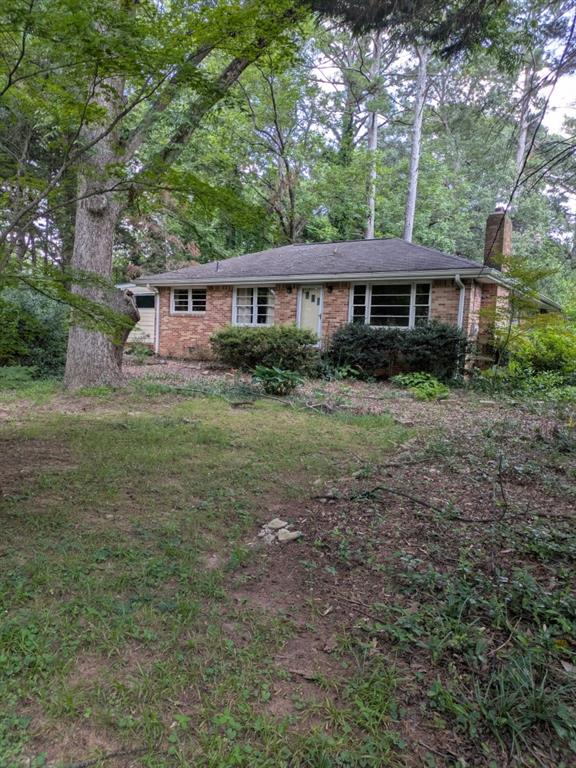 This home needs a complete rehab. It is on a very beautiful large .86 acre level lot with mature trees and sits way back from the road. The backyard is overgrown but used to have nature trails going through. The original brick 2BR 1 bath structure appears to be solid. The roof is estimated to be 12 years old. Original hardwood floors. There have been some additions over the years that need some help. It is on a septic tank rated for 3 BR according to the Seller. Sewer is available at the street. The value is in the large level lot. Bring your contractor/builder to come check it out. Tucker is BOOMING!