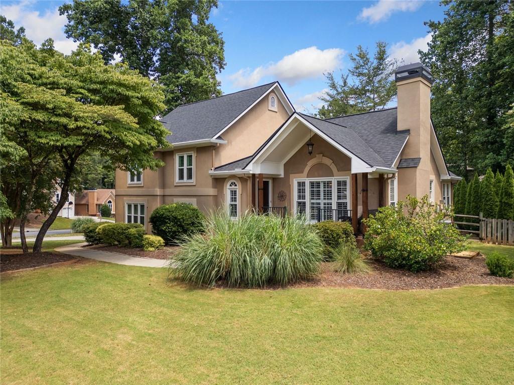Fabulous updated home in sought-after Eagle Watch. Curb Appeal Plus - large grassy front yard and charming front porch. Side entry garage and brick paver patio. Welcoming foyer leads to family room with stone surround fireplace. Light bright interior with vaulted ceilings, extensive hardwoods and modern light fixtures. Upgraded kitchen with granite countertops and island is stylish and functional making cooking a breeze. Sunny dining area for enjoying everyday meals. Two secondary bedrooms share use of upgraded hall bath. Primary king-sized BD with ensuite luxury bath featuring tiled shower and double vanities. Renovated lower level - complete with barn doors - will "Wow" you. Use this as fantastic in-law suite - large living/sleeping areas and renovated bathroom with oversized designer shower. There is even has a private entrance. So many upgrades and special features in this beautiful home ! *Plantation shutters. Newer windows. Newer HVAC system. Floored attic for storage. Brand NEW Roof and Gutters installed May 2025. Newly refreshed and painted Rear Deck. Garage floor has epoxy finish. Synthetic turf backyard. * Wonderful Eagle Watch lifestyle includes 3 Pools, Tennis, Pickleball - Planned Social Events and so much more. Highly rated schools nearby and easy access to Hobgood Park, Lake Allatoona, and vibrant downtown Woodstock. Dreams do come true - Hurry to see!