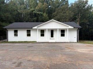 Limitless Possibilities in Carnesville! This 2,400 sq. ft. commercial building offers the perfect canvas for your business dreams. Located in the heart of Carnesville, it features prime road frontage and ample parking, ensuring maximum visibility and accessibility for customers and clients alike. Recently updated with a new architectural roof, windows, exterior doors, fascia, gutters, and a board-and-batten gable, the building shines with a fresh white exterior that sets the tone for professionalism and charm. Inside, the building is a blank slate-ready for your unique vision. With 1,200 sq. ft. on the main level and 1,200 sq. ft. downstairs, you'll have endless flexibility to design a layout that fits your needs, whether retail, office, showroom, or creative space. Don't miss this chance to make your business a reality in a location that offers both character and opportunity.