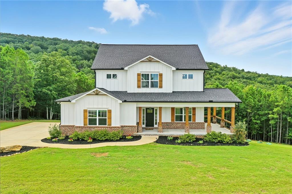 Stunning 5-Bedroom Home on 3 Acres in Stoneledge Community. Welcome to this beautifully designed modern farmhouse, perfectly situated on 3 private acres in the sought-after Stoneledge Community with breathtaking panoramic mountain views. This 5-bedroom, 4-bathroom home blends timeless charm with a highly functional layout, making it ideal for both everyday living and entertaining. Step inside to an open floor plan filled with natural light, showcasing soaring beamed ceilings, wide-plank hardwood floors, and a spacious living area that flows seamlessly into the chef’s kitchen. The kitchen features stone countertops, a waterfall island, custom cabinetry, double ovens, and a stylish range hood—all anchored by a generous island perfect for gathering. The main level owner's suite offers a private retreat, complete with a spa-like bathroom featuring double vanities, a water closet, and an oversized walk-in closet that conveniently connects to the laundry room. Upstairs, you’ll find three spacious bedrooms, an oversized full bath, and a versatile bonus room overlooking the great room.
The finished basement extends the living space with a full bedroom, bathroom, workout room, large living area, storage room, and walk-out access to the backyard. Enjoy outdoor living on the covered back deck, ideal for taking in serene mountain views and the expansive yard. With a 3-acre lot, there’s plenty of space for play, gardening, or future outdoor projects. This home combines style, function, and comfort—all in a peaceful mountain community, yet just minutes from modern conveniences.