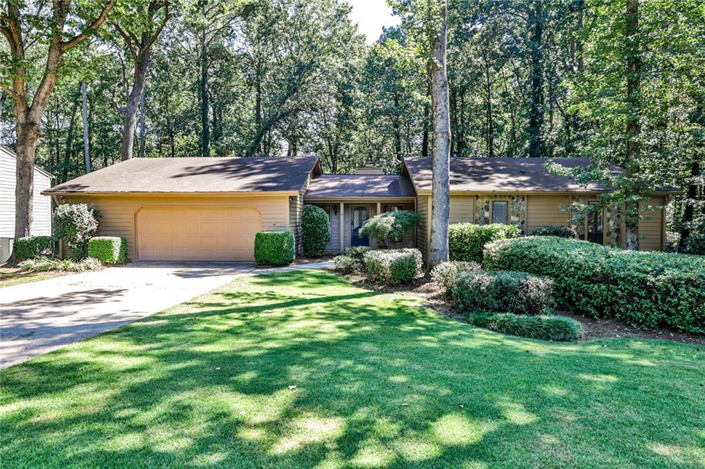 Amazing opportunity in Chimney Springs, one of East Cobb’s most sought-after communities! This large ranch-style home is situated in the heart of the neighborhood on a private lot adjacent to the bike and walking path which leads to Chimney Lake and neighborhood amenities. Ready for you to immediately make it your own, or live in as-is and personalize over time! Walking in the front door, you are greeted with beautiful hardwood floors overlooking an expansive living room with vaulted ceiling and stone fireplace as the centerpiece, an adjacent wet bar, and dual sliding glass doors leading to the back deck. The separate dining room connects to the living room for seamless entertaining and features board and batten and a modern light fixture. The spacious eat-in kitchen and breakfast area with updated light fixtures and beadboard wainscoting provide views of the private backyard through sliding glass doors, allowing access to the oversized deck, perfect for relaxing with your morning cup of coffee or grilling in the evenings while entertaining friends! Laundry room with sink connects the garage to the kitchen, creating an ideal drop spot and mud room. The primary suite has a vaulted ceiling with wood beam accent, two spacious closets and ensuite bathroom with recently updated shower. Two additional bedrooms and additional full bathroom complete the main level. The terrace level basement has two large finished rooms ideal for a workout space, home office or playroom and two additional unfinished rooms for storage or an opportunity for you to finish as your own. Outside of the basement door, mulched side yard is ready for a fire pit or a swing set! Natural path in the backyard creates a peaceful retreat with room for you to customize the almost half an acre to your liking. Interior painted 2025, exterior painted Sept 2021, newer HVAC system and newer water heater. Chimney Springs is a very social and amenity-rich neighborhood. Take the trail adjacent to the home and enjoy the swimming pool, clubhouse, tennis and pickle ball courts, lake with bike and walking path, playgrounds, basketball court and activity field. Zoned for top-rated Pope High School, Hightower Trail Middle and Tritt Elementary. This Chimney Springs home is situated within minutes from Avenue East Cobb, Downtown Roswell and offers unmatched convenience in the heart of East Cobb. Welcome Home!