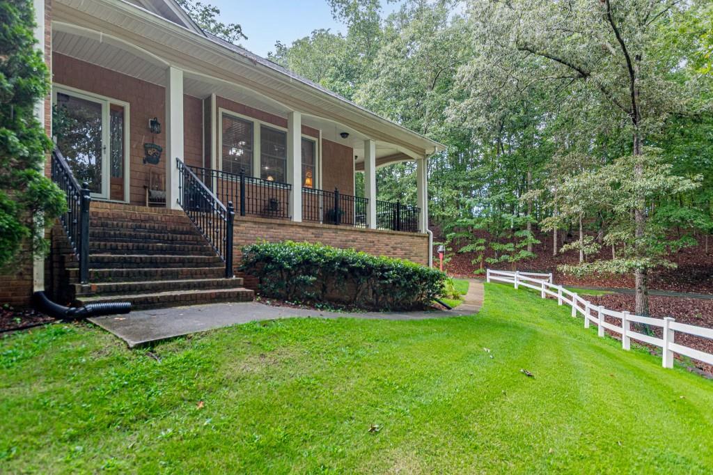 Beautiful home nestled on over 2 private acres! Welcoming foyer opens to vaulted great room w/ rock fireplace and gas logs. The open-concept design flows into a spacious chef's kitchen with rich stained cabinetry, a center island, and a cozy built-in window seat. Appliances, including the refrigerator, remain! Enjoy family meals in the large dining area, and take advantage of the convenient mudroom with extra storage. The oversized owner's suite on the main level boasts two generous closets, double vanities, a garden tub, and a separate shower. Laundry just off the owner's suite. Relax on the lovely screened porch, accessible from both the great room and the office. The finished lower level offers a huge flex space perfect as a family room, bonus area, or media room. Outside, you'll find a 12x32 powered workshop, a matching 12x32 open shed, a fenced backyard with dog run, and multiple parking options including an attached garage and detached carport. Additional features include Underground utilities, Security system, Top-rated school district The perfect blend of privacy, functionality, and location schedule your showing today! Let's get moving!