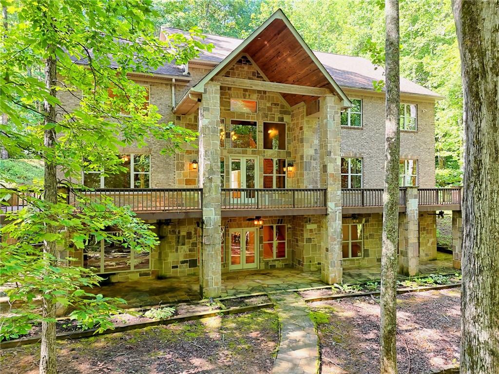 Begin relaxing as you slowly start up the private drive to this stunning custom brick/stone mountain retreat in Chinkapin at Burton! Enjoy the 10.54 acres (2 additional lots are being included in this sale-lots 26 & 27) of natural beauty w/seasonal views & a quiet serene walking path surround the property. This home offers 6 bedrooms/4 full baths complete w/an elevator to easily take you to each of the 3 floors. The great room boasts a massive fireplace w/decorative brick work & flanking built-ins, large windows & French door leading to wrap around deck. GR opens to the kitchen w/built-in stone breakfast bar & stone arched vent hood, granite, plenty of cabinets & serving space, walk-in pantry. Laundry room is adjacent to kitchen. Owners suite is on the main floor w/en-suite featuring double vanities, double showerheads, seperate tub & walk-in closet w/California closet system through out home. Split spacious bedrooms share jack-n-jill baths. Entire home is handicap accessible w/entrance ramp, wide doors/halls, roll=in shower, lower bathroom vanity & elevator. Upstairs has 2nd large den area overlooking main level, home office, spacious bedrooms, jack-n-jill bath & space for a bunkroom. Lower level presents large 3rd entertaining space w/bar area, pool room, huge 6th bedroom & 4th bath. Storage closets, mechanical room with two water heaters, french doors open onto wrap-around terrace level. Circular driveway. This home has been lovingly maintained and is the perfect home to host lots of friends and family in the beautiful mountains. Plenty of wildlife abounds. Close to beautiful Lake Burton, kayaking, hiking, dining/restaurants, Waterfall at Burton. DON'T FORGET: Adjoining lots 26 & 27 are included in this sale for a total of 10.54 acres!!!
