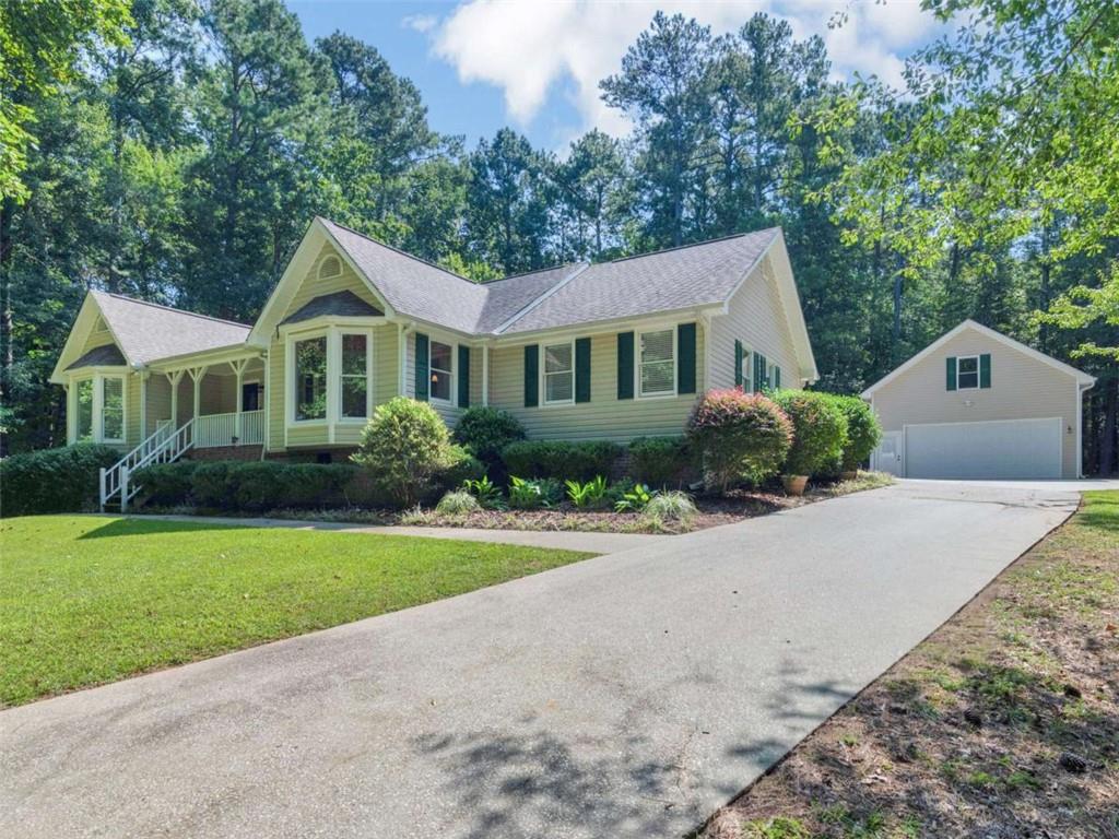 Welcome to the Lake Dow community! This beautiful home offers 3 bedrooms plus a versatile flex room that can serve as an office or sunroom. The inviting split bedroom plan features an open concept design with a stunning eat-in kitchen featuring granite countertops, stainless steel appliances, farmhouse sink, updated cabinetry with pantry space, an island with breakfast bar and a breakfast area with bay window for natural light. Kitchen opens to a cozy family room with fireplace and trey ceiling. The spacious primary suite features a bay window perfect for a reading nook, an updated bath with jetted tub, oversized tile shower, dual vanities, and a huge walk-in closet. Two additional bedrooms on the opposite side of the home share a full bath that is also updated. Hardwood flooring runs throughout all main living areas and bedrooms, while tile accents the baths and laundry room. Car enthusiasts and hobbyists will love the 4-car garage setup-an attached 2-car garage plus a detached 22x24 garage with lean-to and concrete pad, perfect for a golf cart or small boat. Above the detached garage, you'll find a massive unfinished bonus room with endless possibilities. All on a private 1.25-acre wooded cul-de-sac lot, the home's large back deck is perfect for grilling out or relaxing outdoors.**Bonus!** Take advantage of an assumable loan with a fantastic 4.75% rate-ask for details! Neighborhood amenities include lake access and optional memberships for pool, gym, and golf course. Don't miss this incredible opportunity to own in Lake Dow!