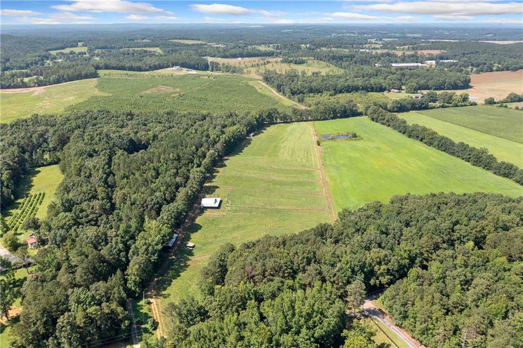 Country living at its finest. This picturesque 14+/- acre property features rolling pastures, multiple large paddocks, and a spacious back field—ideal for horses or other livestock. A wooded area at the front offers natural privacy and seclusion, creating a serene setting for your rural retreat. The well-appointed six-stall barn is ready for your animals, and covered storage space offers a convenience place to store whatever you need as you build your dream home. Whether you're seeking an equestrian property or a blank canvas for your dream estate, this land offers both comfort and endless potential. Schedule your private showing today and discover the best of country living.