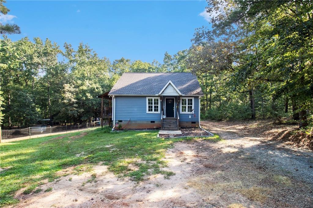 Welcome to 168 Elm Road, Carlton, GA – Your Private Retreat in Madison County
Nestled on over 12 secluded, wooded acres, this charming cottage-style home offers the perfect blend of rustic tranquility and modern comfort. A long, meandering driveway leads you to your own private oasis, where nature and privacy all around.
Inside, you’ll find a warm and inviting open-concept living space, beautifully accented with cozy wood paneling and bathed in natural light. The kitchen is a chef’s delight, featuring granite countertops, stainless steel appliances, a stylish subway tile backsplash, and a functional center island—ideal for entertaining or everyday living.
Tucked behind a custom sliding barn door, the dedicated laundry area adds both charm and convenience. The spacious primary suite includes a private en suite bath, while a second bedroom and full guest bath provide comfort for family or visitors.
Step outside to enjoy endless hours of relaxation on the back deck, overlooking your expansive property with boundless potential—whether it's hiking, trail riding, gardening, or starting a hobby farm. Portions of the land are already fenced and include multiple outbuildings, such as a 12x20 utility shed—perfect for storage or small livestock.
The detached 30x30 two-car garage/workshop offers ample room for vehicles, tools, and recreational gear—making it an ideal space for hobbyists or outdoor enthusiasts.
Don’t miss this rare opportunity to own your own slice of paradise in Madison County. Peace, privacy, and potential await at 168 Elm Road.