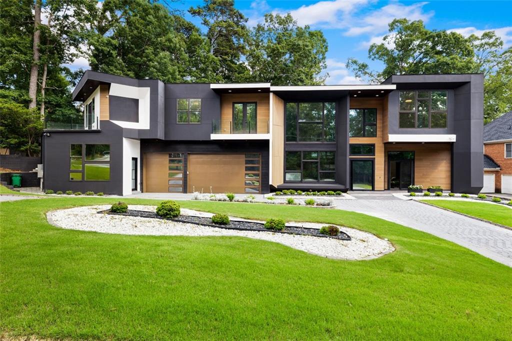 Introducing The Greenglade Modern, a striking modern estate that delivers bold architecture and refined living in the heart of Oak Grove. Set just minutes from Emory University, the CDC, and vibrant Decatur, this exceptional residence offers a rare opportunity to live at the intersection of cutting-edge design and urban convenience. Showcasing nearly 6,800 square feet of light-filled interiors, this 7-bedroom, 8-bathroom home is a masterclass in contemporary luxury. Clean lines, soaring ceilings, and a dramatic floating staircase welcome you into a space defined by openness and sophistication. Expansive glass walls create seamless indoor-outdoor flow, bathing the home in natural light. At the center of the home is a true chef’s kitchen—a stunning culinary space designed for both form and function. Outfitted with Wolf and Sub-Zero appliances, the kitchen features a 48-inch gas range with double ovens, integrated refrigerator and freezer, built-in coffee system, sleek custom cabinetry, and a dramatic waterfall quartz island. A walk-in pantry, designer lighting, and abundant prep space make this the ideal environment for both everyday meals and high-end entertaining. The kitchen flows effortlessly into the expansive dining area and dramatic great room with soaring 20-foot ceilings. Oversized sliding doors open to a covered outdoor lounge with a modern fireplace and a beautifully landscaped backyard—perfect for al fresco living. The main floor features both a private guest suite and a separate living quarters located on the side of the home. This self-contained suite includes its own full kitchen, combined living/bedroom space, full bathroom, and a private exterior entrance—an ideal setup for in-laws, guests, or extended stays. Upstairs, the primary suite offers a luxurious private retreat complete with a spa-inspired bathroom, oversized glass shower, soaking tub, dual vanities, and custom walk-in closets. Additional upper-level en-suite bedrooms and a loft-style flex space provide room for work, play, or relaxation. Located in one of Atlanta’s most desirable neighborhoods, this modern masterpiece blends forward-thinking architecture with unmatched convenience—just moments from top schools, parks, Emory, the CDC, CHOA, and an array of shops and restaurants. Elevate your lifestyle at The Greenglade Modern—where innovative design meets everyday comfort in the heart of Atlanta. Contact us for a private showing!