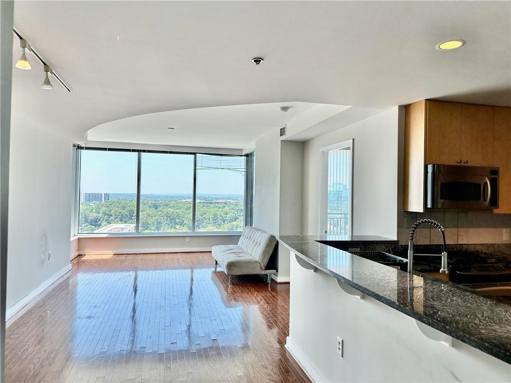 Light filled 1 bedroom on the 18th floor. Unique feature compared to other 1 bedrooms is this unit has a large en-suite bathroom that wraps around to the 
kitchen for easy access. It can also be turned into a powder room by simply adding a door/divider. Features new faucets in kitchen and bath, exotic granite, glass shower door.  HVAC REPLACED WITHIN THE LAST COUPLE OF YEARS! Incredible sunset views, private balcony!! Fine Dining and upscale shopping all within 1 mile. 5 Star Amenities Package Includes: TOP FLOOR Sky Lounge w/Bartender service & BREATHTAKING 180 Degree VIEWS, Guest Suite, Pool Bar in Summer, Doorman/Porter Service, Mirrored Yoga Studio, European Spa, Wine Cellar, Salt Water Pool, Pet Walk, Private Massage Room, 24 hr concierge, Park with fountains, right next door. Marta just steps away! PLEASE NOTE, BUCKHEAD GRAND IS A STRICTLY SMOKE FREE BUILDING.  Seller would prefer to sell "as is".  Wine storage Unit included!