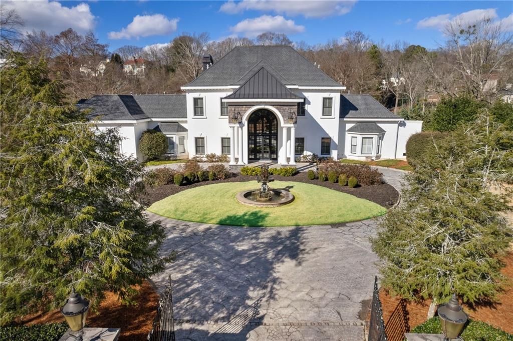 Price improvement of $65,000 below recently appraised value! Step into another world of privacy and luxury nestled on almost 8 acres minutes from the city center. Residing on coveted Columns Drive, this equestrian estate across from the Chattahoochee River is an oasis like no other. Magnificently manicured grounds create a tranquil, park like setting equipped with a 5 stall barn,5 pastures, paddock, large private pond with fountain & dock, walking trail, salt water pool/spa, tennis court, playground, gazebo and greenhouse. The 2 story carriage house(currently a workshop) with full finished bath and 2 car garage can easily be converted into an office/studio/Airbnb/caretaker's cottage and is accessible by a separate gated service entrance to the property. This remarkable residence has been updated to today's living standards, exuding a blend of traditional and modern architectural elements throughout. Relax in your luxurious master suite conveniently located on the main level. The stunning staircase leads to 4 generously sized bedrooms on the East wing with all walk in closets and large ensuite baths. The West wind has 2 spacious options for an au pair or in-law suite along with laundry and direct access to the back staircase. The 3rd floor bonus room is equipped with a full bar and half bath, providing endless possibilities for a game room, theatre, or additional entertaining. Renovated with discerning taste and quality, this home was designed for hosting large gatherings. The fabulous white chef's kitchen with new Italian marble and hardwood floors also has a separate butler's pantry/prep station with a fully equipped walk in pantry. Beautiful arched French doors surround the entire pool/spa area where you can unwind overlooking the fabulous pond and hear nothing but the sounds of nature. Imagine taking a morning stroll around the lake as you watch the sunrise or relax on your dock in the evening. Maybe evening slip your kayak in the water for a leisurely paddle. This fully sustainable estate has smart home features, highly efficient newer HVACs, new tankless water heaters, pool with new tile surround, Tesla chargers, and a large generator more than sufficient to power all buildings on the property. The residence is fully fenced with 2 gated entrances for added convenience. This remarkable property is one of a kind and sure to impress! Low Cobb taxes, Sope Creek, Dickerson, Walton schools with quick access to the state Chattahoochee River Park for hiking, biking, walking and kayaking. Agents please see private remarks to schedule showing.