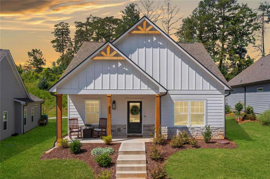 Welcome home to this sought-after ranch plan that blends comfort, style, and convenience all on one level. This well-designed home has 3 bedrooms and 2 bathrooms. It includes a covered front porch and a rear porch. Both are great for your morning coffee or relaxing in the evening.
Step inside to find a gorgeous kitchen. It showcases white cabinets and solid surface countertops. There’s also undermount lighting and stylish pendant lights. The working island flows into a spacious dining area. The seamless flow into the large family room creates an inviting space to gather, complete with a cozy gas fireplace with direct vent and gas logs.
Escape to the Primary suite. Enjoy the oversized tile shower and elegant ceramic tile flooring in the en suite bath. The additional two bedrooms offer flexibility for guests, home office, or hobbies.
In the main living areas, laundry room, and secondary bathroom, the luxury vinyl plank flooring is both durable and beautiful.
You’re just a short walk from charming Downtown Ball Ground. Enjoy local restaurants, unique shops, and community events nearby. This home offers an ideal blend of modern comfort and small-town living. Come see why this is the perfect fit for your lifestyle.