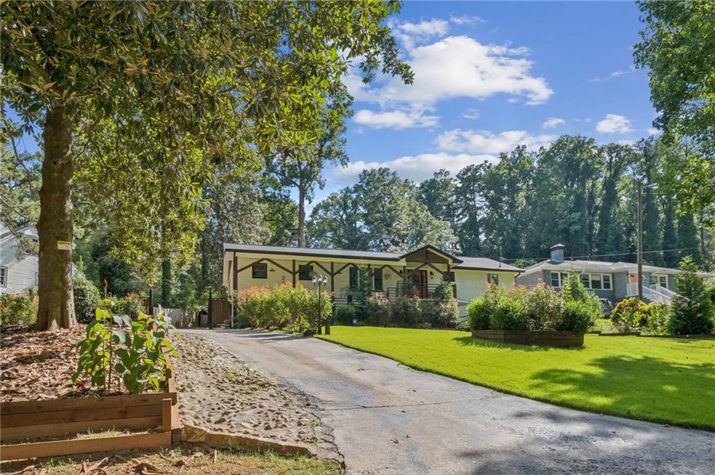 Beautifully Maintained 4-Sided Brick Home in Prime Atlanta Location! This spacious residence offers 4 beds and 2 baths on the main level, plus a fully finished 3 bed/2 bath guest suite on the lower level — perfect for a growing family or potential rental income. Step into the inviting open floor plan featuring hardwood floors throughout and a large entry foyer. The main kitchen is upgraded with granite countertops, stainless steel appliances, and a center island, ideal for entertaining. The oversized primary suite boasts a jacuzzi tub and double vanity. Secondary bedrooms are generously sized. The lower-level guest suite mirrors the upper with an open-concept layout, full kitchen with granite counters and stainless steel appliances, and updated finishes throughout. Enjoy outdoor living with a rear deck, patio, and a fully fenced, expansive yard — perfect for gatherings. Additional features include upgraded gutters and a converted carport offering additional living space. Don’t miss this incredible opportunity!