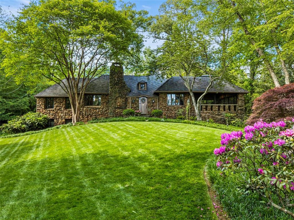 This special home has been the subject of multiple advertising campaigns and the site of 3 Botanical Garden Tours. It truly is a landmark home for Historic Brookhaven with one of the best views overlooking Capital City Golf Course. It is impossible to describe the charm of the living area. These sellers have invested over 50 years of love into this home and when you sit in the Norman Askins designed huge garden room addition with its intricate ceiling and view of both the golf course and the gardens, you know why they love it. It is situated on a double lot with spectacular backyard gardens complete with a delightful garden house and water features. There is plenty of room to expand the home if so desired. There is a main-level master bedroom with his and hers baths. A second main level bedroom is currently furnished and used as a sitting room.
