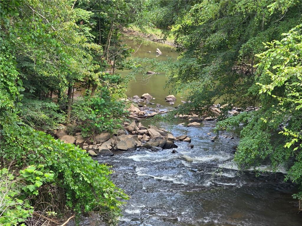 Discover the perfect blend of privacy, adventure, and natural beauty on this stunning 5-acre lot nestled along Bear Creek. Just minutes from local shopping yet worlds away in peaceful seclusion. Bear Creek flows directly into the Chattahoochee River, giving you rare water access right from your own property. Launch an airboat or raft for an afternoon escape, or simply relax and take in the sounds of nature. Depending on your future home’s elevation, you could enjoy breathtaking views of the river from your own porch. This unique property is not in a flood plain, making it an ideal spot to build your dream home. Embrace rural living with all the modern conveniences close by. This is Georgia living at its finest.