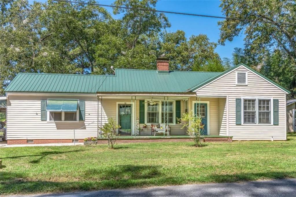 Welcome to 78 Willow Dr. - a charming 2 bed, 2 bath home on a spacious 0.6-acre lot in the heart of downtown Woodbury. Enjoy relaxing on the front porch or soaking in the natural light from the large picture windows. Inside, you'll find new LVP flooring and an updated kitchen that combine style with easy maintenance. The fenced backyard is perfect for pets, gardening, or play, and includes a powered storage shed/workshop. Two open-air carport-style buildings provide extra storage or could be converted to a chicken run/coop. A separate outbuilding offers endless opportunities for a guest suite, she-shed, tiny home, Airbnb, or creative space-just steps from downtown shops and amenities. Whether you're searching for small-town charm, investment potential, or a cozy place to call home, this property has it all!
