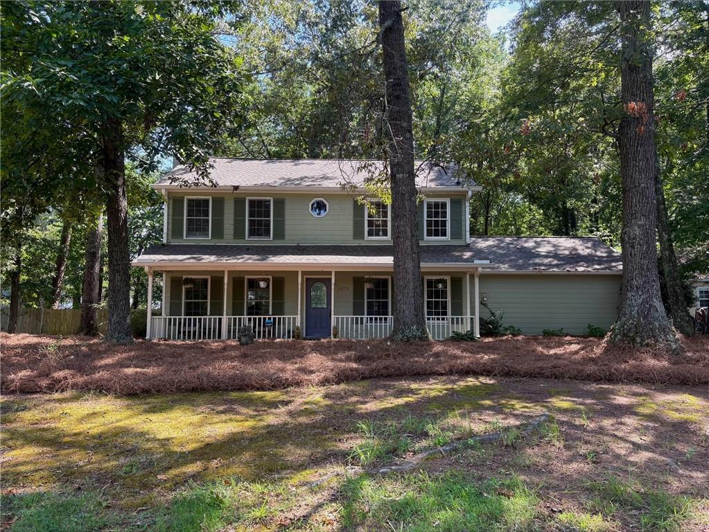 This charming 3-bedroom, 2.5-bath residence offers 1,850 square feet of inviting living space filled with natural light and timeless details. Enjoy your mornings on the covered front patio, complete with classic wooden balusters, an ideal spot to sit and relax rain or shine. Step inside to a spacious living room with a gorgeous marble fireplace, flowing seamlessly into a cozy sunroom with built-in cabinetry, perfect for reading, entertaining, or simply unwinding. The country-style kitchen features stainless steel appliances, a wooden island, a pantry, and a lovely breakfast area that overlooks the backyard. A formal dining room provides the perfect setting for hosting guests, while the two-car garage offers direct access and remote-controlled doors for convenience. Out back, you’ll find a peaceful and private yard with a generous wood deck, perfect for outdoor dining and gatherings. Two sheds offer plenty of extra storage. Upstairs, the owner’s suite is a true retreat, complete with vinyl floors, a second marble fireplace, a spa-like bathroom with a soaking tub, separate shower, double vanity, and generous closet space. A built-in bookshelf in the hallway adds a thoughtful and stylish touch.
Ideally located just 30 minutes from downtown Atlanta and 20 minutes from scenic Stone Mountain Park, this home offers the perfect blend of charm, privacy, and accessibility. Don’t miss the opportunity to make this one-of-a-kind home yours.