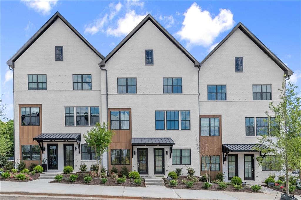 Our Model home is officially Open!! You won't want to miss our Spring Savings!!!!
Welcome to The Anniston at The Gathering, a stunning Contemporary style townhome designed for modern living. This beautifully crafted home offers 1,644 square feet of thoughtfully designed space, features two bedrooms, a flex space, and three luxurious bathrooms, perfectly blending comfort and style. As you enter the Anniston you will find a versatile terrace level that includes a cozy flex space, a full bathroom, and convenient access to the garage. Ascend to the main living area on the second floor, where 10-foot ceilings and an open-concept layout seamlessly integrates the kitchen, dining area and living room. The gourmet kitchen showcases quartz countertops, KitchenAid appliances and maple cabinetry. This space is perfect for entertaining guests or enjoying a quiet evening at home. Step out onto the covered deck off the living area to enjoy fresh air and outdoor relaxation. The third floor is dedicated to restful retreats. The primary suite boasts a walk-in closet and a well-appointed bathroom featuring double vanities, quartz countertops and a glass shower providing a serene sanctuary. A second bedroom, complete with its own full bath, offers comfort and privacy for family members or guests. The Gathering is a vibrant new community, just minutes from downtown Alpharetta, Avalon and top-rated schools. Walk out your front door and hop right on the popular Alpha Loop. Enjoy our community amenities such as a Community Garden, Firepit and Dog Park. This home provides the ultimate modern suburban living. Experience the perfect combination of style, comfort and convenience!! This home is MOVE-IN READY!! Agent is on-site Monday, Tuesday & Saturday (10:00-6:00) and Wednesday and Sunday (1:00-6:00). Photos are of actual unit.