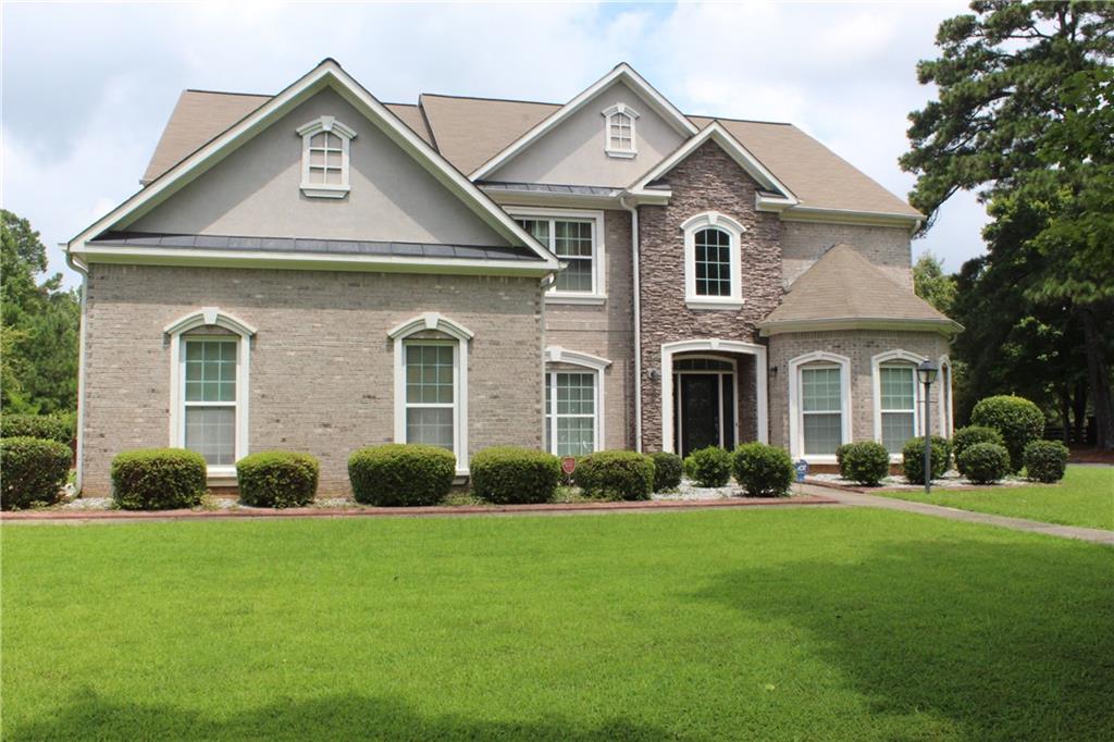 Welcome to 7553 The Lakes Drive. This home is in a prime location that combines the charm of suburban living with the convenience of easy access to the city. Gorgeous 3 sided brick home conveniently located in upscale neighborhood just about 16 minutes from the Hartsfield Jackson Airport. This home makes gracious first impression, from the curb appeal to the striking high ceiling to the gleaming hardwood floors. This home boasts 3 cars garage, two story ceiling in family room, massive kitchen overlooking family room with 42 inches cabinets, granite countertops, stainless steel appliances, double oven. Enjoy the beautiful arched doorways as you move around in the house plus tray ceilings. In master bath enjoy the oversized shower, jetted tub, separate vanities, his/her walk in closet. On the main floor spacious bedroom with walk in closet, full bath. Step outside and go for a walk in the subdivision and enjoy the lakes, tennis courts, basketball court, pool and playground area. With fenced backyard there is nothing to do but move in after closing, and welcome home again.