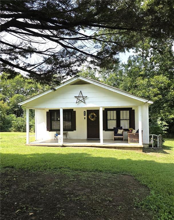 Charming cottage--style home tucked away on a spacious city lot. Enjoy relaxing on the welcoming rocking chair front porch before stepping inside to an open living room, kitchen and dining area. This cozy home offers 2 bedrooms, 1 bath, and a large storage building in the back-perfect for all your extra needs.