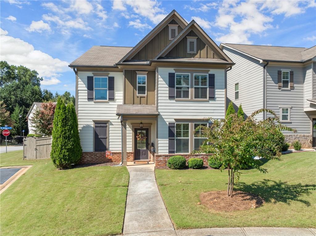 This charming 4-bedroom, 2.5-bath home is perfectly located within walking distance to Downtown Flowery Branch and Lake Lanier. Step across the street to the walking path that leads directly to Safe Harbor Hideaway Bay and enjoy lunch or dinner on the water at Fish Tales, or stroll just half a mile to experience the growing selection of new restaurants in Downtown Flowery Branch. Inside, you’ll find an inviting open floor plan with a spacious kitchen featuring newer stainless steel appliances and a pantry, a dining area, and a living room centered around a cozy brick fireplace, plus a formal dining room or office on the main level. The main floor also offers durable LVP flooring, while upstairs has freshly cleaned carpet throughout the bedrooms. A screened porch overlooks the privacy-fenced backyard, ideal for entertaining or relaxing in this quiet community. Additional highlights include a two-car garage with plenty of parking, low HOA fees with yard maintenance included so you’ll never cut grass again, and a beautifully maintained interior with thoughtful updates. This home blends convenience, comfort, and lifestyle—offering everything you need to enjoy the best of Flowery Branch living.