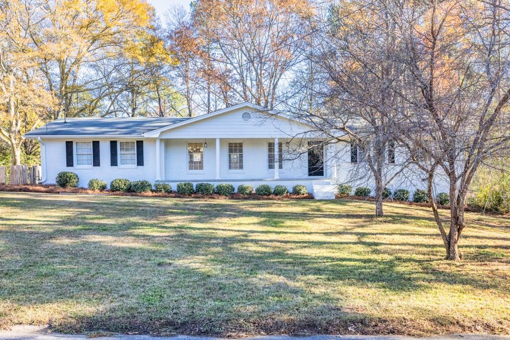 This well-maintained, four-sided brick home, painted white with stylish black accents, sits on a spacious half-acre lot. It. boasts a large, usable front yard and a private backyard featuring an inground swimming pool with newer equipment and a large storage shed. Inside, the home offers four bedrooms and two fully renovated bathrooms, with LVP flooring throughout, neutral white walls, and modern light fixtures. The kitchen is a chef's dream with brand-new shaker cabinets, leathered granite countertops, a tiled backsplash, and all-new stainless steel appliances, including a gas cooktop and refrigerator. The open-concept floor plan is perfect for entertaining, and a cozy wood-burning fireplace adds warmth to the living space. The fourth bedroom can be used as a rec room or bonus room. Enjoy the serene views from the all-glass sunroom, overlooking the backyard. Located in a quiet neighborhood, this home presents a fantastic opportunity for both comfortable living and investment potential.