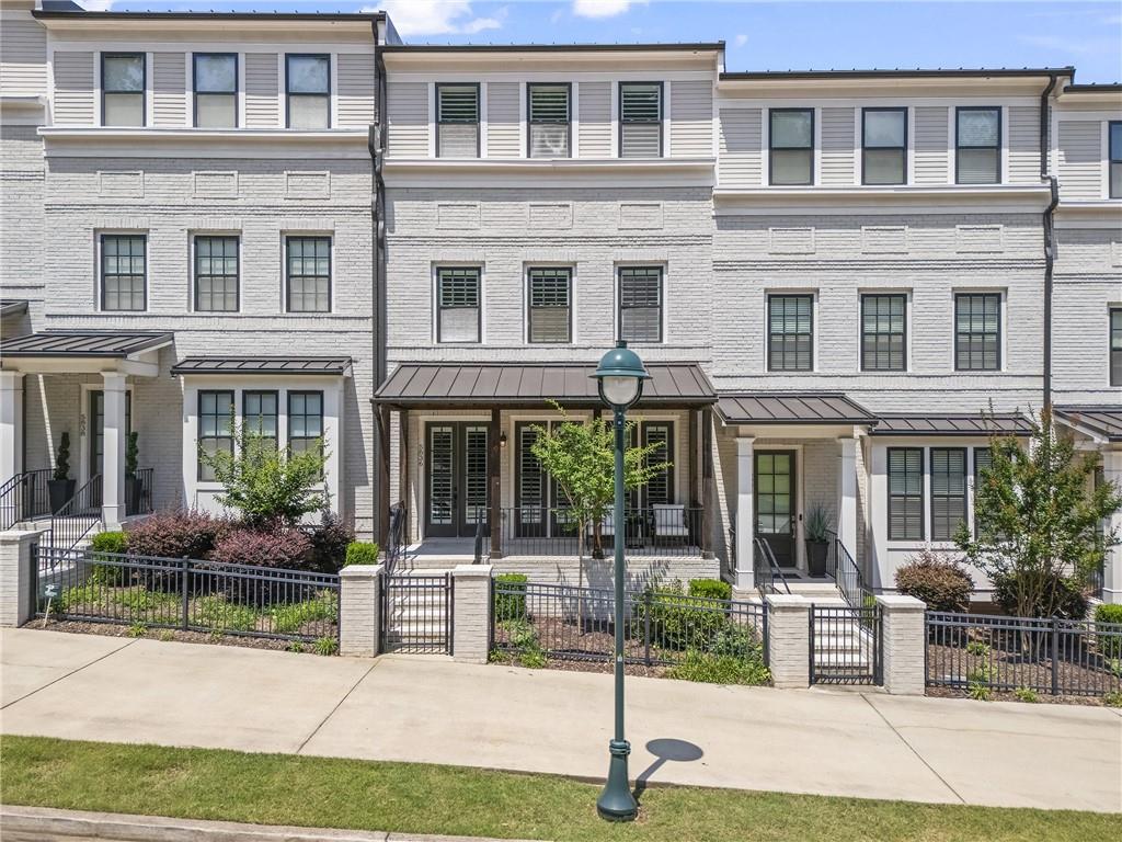 Almost new construction luxury townhome in the heart of Sandy Springs. 4 bedroom, 4.5 bathroom with elevator access on all levels. Rooftop patio with peaceful private tree view in gated John Weiland's Atwater. All levels are bathed in natural sunlight with wide white shutters. Enjoy French doors, thoughtful built ins and multiple serene outdoor spaces. Living room with custom built in bookcases, cabinets and gas fireplace with gorgeous stone surround prewired for television. Wide plank hardwood floors. Extra large quartz kitchen island with large storage cabinets on both sides and large undermount sink with upgraded Moen stainless steel faucet. Chef's kitchen with six burner Kitchen Aid stainless gas stove with stainless vent hood, large convection oven, built in microwave, dishwasher and large built in pantry with multiple pull out shelves. Custom under cabinet and display cabinet lighting. Soft close drawers. Relax in the kitchen with the view of a mature tree scape. Enjoy the main level rear deck and a rooftop terrace for entertaining with privacy from neighbors and relaxing sunsets. Owners Suite with East facing windows and large walk in closet. Enormous indulgent spa bathroom with two separate vanities, large soaking tub and separate oversized tiled shower. Water closet for privacy. Full size laundry room with cabinets on the same level. Three secondary bedrooms and a large rooftop den that extends to a partially covered rooftop terrace with a mature tree view for privacy. All bedrooms have new carpet. All bathrooms have quartz vanities and Kohler fixtures. Built in alarm system. Low monthly $300 HOA dues include gates, roof, exterior, grounds, sparkling pool with cabana, reserve fund and several pocket parks tucked behind the gates with benches to relax. New park with playground, sports court and pickleball is super close and just outside the neighborhood across the side street. Impeccably maintained. Shows like a new home. Elevator just serviced too. Immaculate two car garage with elevator close to entry for groceries, luggage and convenience. Built in drop zone for packages, shoes and bags. Move in and live the lifestyle you've dreamed and explore some of Atlanta's top restaurants just outside the neighborhood. Sandy Springs Farmers Market, riverfront Cochran Shoals Park in the Chattahoochee River National Recreation Area, The Battery where the Atlanta Braves play baseball full of shops and restaurants and so much more to explore. Amazing public and private school options are close. Minutes to Cobb Energy Performing Arts Centre for operas and ballet or Chastain Park for horses and golf. Sidewalks to Sandy Springs Performing Arts Center, Whole Foods, cinema, City Springs, pilates studio, pet store, Trader Joe's and more.