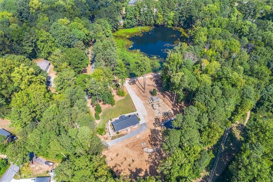 Welcome to this extraordinary once-in-a-lifetime opportunity to make this 3-bedroom, 2-bathroom house your HOME! Boasting 1,850 square feet of beautifully upgraded living space on a professionally landscaped 7.5-acre East Cobb Marietta property. With a 2-acre private fishing lake featuring a floating dock, new drainage system, and an aeration setup, this home offers a tranquil and self-sufficient lifestyle perfect for families, homesteaders, or potential Airbnb hosts. The property is a true outdoor retreat, featuring a dedicated outdoor recreation area with four camping spots, a walking trail, an outhouse, a fishing house with a grill area and deck, a she-shed/greenhouse with power and water, a huge barn/storage shed, and wine and grain storage/ root cellar.

Inside, you'll find original hardwood floors throughout most of the home. The open floor plan is filled with natural light, centered around a modern, updated kitchen complete with premium appliances, reclaimed wood shelving, and a garden kitchen window. The home also includes thoughtful touches like a coffee bar with built-in mini fridge, hanging pot cabinet, and an easy access laundry setup. Upgrades include a new roof, new windows, spray foam insulation throughout, new main water line, durable epoxy flooring, new fixtures throughout, new plumbing and gas lines, new electrical wiring and electrical panel, and a tankless hot water heater with a recirculating system.

For storage and convenience, the attic—spanning the same square footage as the home—is easily accessible via a 500-pound capacity freight elevator, making moving and organizing a breeze. Additionally, the property includes raised garden beds with irrigation, an orchard with pear, apple, and peach trees, and a barn equipped with power and water. Despite its feeling of seclusion, this property is just minutes from popular dining, shopping, major interstates, and offers easy access to the Atlanta Airport. I-75 is literally about 2 minutes away! Whether you're looking for a peaceful family retreat, lots of wildlife and great fishing or a unique Airbnb opportunity, this home has it all. Property also has multiple buildable lots.