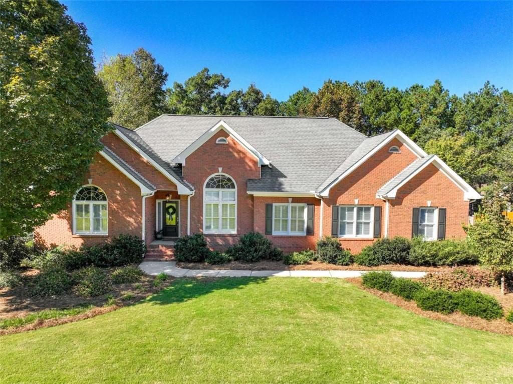 Welcome to this exceptionally well-maintained and thoughtfully updated 4 bedroom, 3.5 bathroom three-sided brick home located in the highly sought-after Lakehaven neighborhood - a premier community offering access to tennis courts, two swimming pools, and top-rated Union Grove schools. This beautiful property sits on a spacious, professionally landscaped lot with a WiFi-controlled irrigation system, an attached two-car garage, a separate basement-level garage, and a fully fenced backyard featuring a main-level deck, lower patio, and a custom stone firepit accented by LED path lighting - the perfect setup for outdoor living and entertaining. Inside, every detail reflects quality and care - from the gleaming hardwood floors throughout to the elegant two-piece crown and trim moulding and dimmable lighting in most rooms. The inviting foyer opens to a formal dining room on the right, showcasing high ceilings and abundant natural light. The family room strikes the perfect balance between grand and cozy with its tray ceilings and charming fireplace, creating an ideal space for gathering and relaxation. The kitchen is truly the heart of the home - professionally updated and designed for both style and function. It features stainless steel appliances, a custom vent hood, natural stone countertops, LED under-cabinet lighting, a breakfast bar, and a bright breakfast area. Just off the kitchen is a beautifully renovated laundry room with a granite countered sink and built-in storage as well as a convenient half bath. The oversized primary suite offers a tranquil retreat with tray ceilings, two walk-in closets, and a luxurious updated en suite bathroom complete with double vanities, a stand-alone soaking tub, and a walk-in shower. On the opposite side of the main level (in a desirable split-bedroom layout) are two additional spacious bedrooms with access to an updated full bath. The finished basement provides exceptional flexibility and could serve as a complete in-law suite. It includes a kitchenette, a comfortable living area, a private bedroom, and a full bath. Additionally, the lower level offers a separate office (which could function as a fifth bedroom), a walk-in storage room, and a 512 sq ft workshop - perfect for hobbies or projects. From its meticulously maintained interior to the beautifully designed outdoor spaces and resort-style neighborhood amenities, this Lakehaven home offers the perfect blend of comfort, craftsmanship, and convenience in one of the most desirable school districts in the area.