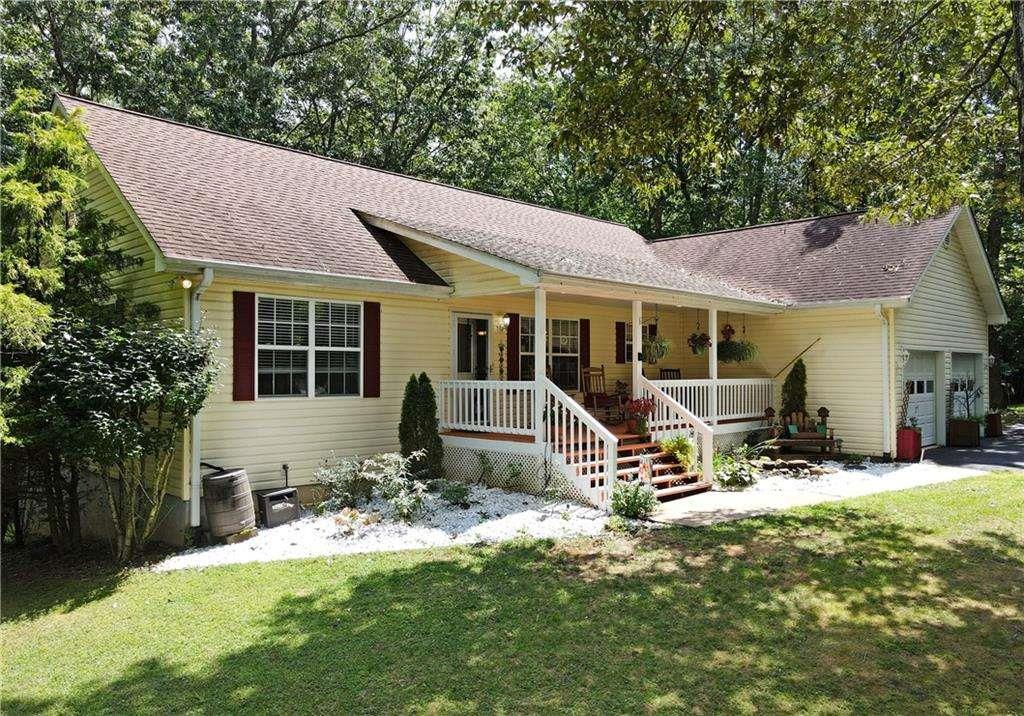 This ranch-style home blends contemporary charm with comfort. The great room features a cathedral ceiling, hardwood floors, recessed lighting, and a gas log fireplace. Enjoy the outdoors with a screened porch and an additional open deck overlooking the woods. The main-level master suite includes a large walk-in shower, soaking tub, and temperature-controlled tiled flooring. The finished terrace level offers a rec room, private office/craft room with fiber optic, bedroom and bath, plus an extra-large storage room with shelves. Additional highlights include a rocking chair front porch, greenhouse, and shed. The property is well-maintained and updated, with a private community boat ramp and deeded lake access. No restrictions for storing boats or RVs, with plenty of space on the extra-wide, paved circular driveway. Two-car garage and fiber optic installed.