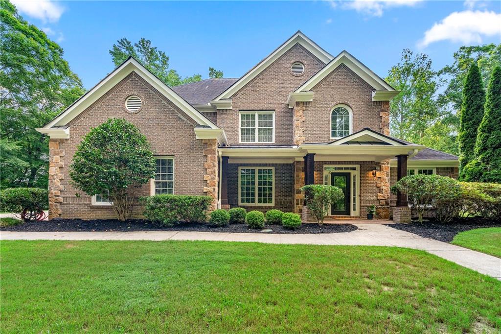 Custom-built and recently updated with a brand-new roof and hot water heater, this stunning brick and stone home is nestled in a quiet, enclave-style neighborhood on over half an acre of exceptionally private land. Backing up to a picturesque horse farm with no plans for future development, the property offers rare privacy and serene views in a truly one-of-a-kind setting. A welcoming front porch sets the tone, leading into a light and bright interior with fresh neutral paint, abundant natural light, and thoughtful updates throughout. Enjoy new flooring upstairs and downstairs (excluding the kitchen), new interior and exterior paint, updated light fixtures, and stylish new door hardware.
The kitchen is as functional as it is beautiful, featuring soft-close cabinetry, new drawers, plentiful storage, and all appliances less than five years old. It flows effortlessly into the impressive living room, where soaring ceilings, a floor-to-ceiling stone fireplace, and a wall of windows create a stunning focal point. The main level includes a guest bedroom with private ensuite, a laundry room with utility sink, and multiple living spaces ideal for everyday comfort and entertaining.
Upstairs, the oversized primary suite is a private retreat with tray ceiling, generous windows, a spa-like bath with dual vanities, a soaking tub, and large closets. Two additional upstairs bedrooms share a spacious connecting bathroom, offering both privacy and convenience for family or guests. Additional highlights include an oversized sunroom perfect for year-round enjoyment, a stone patio with outdoor fireplace and deck space, a new high-end hot tub, flat level yard and driveway, and a new HVAC system installed in 2021. Owner financing may be available.