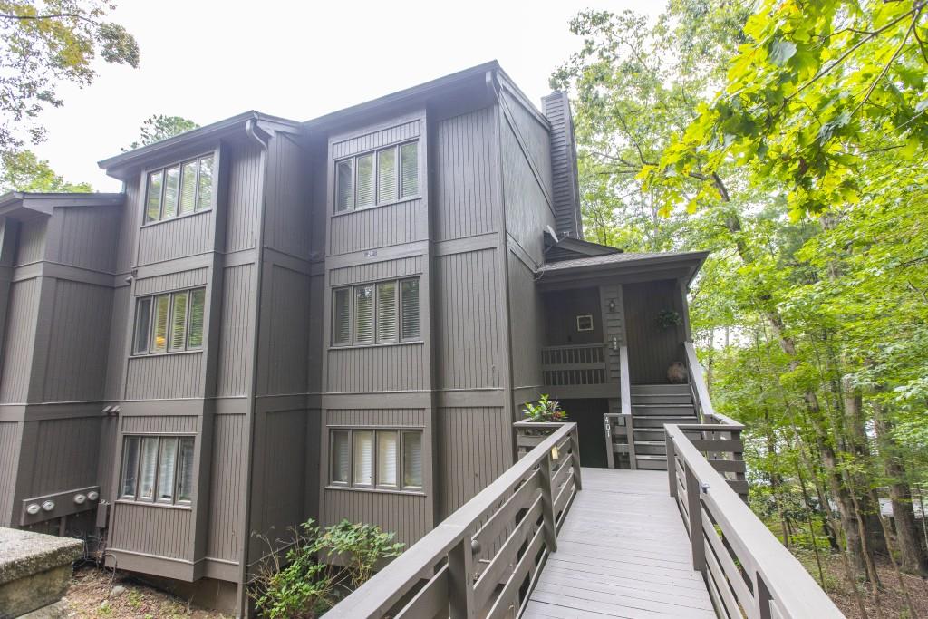 Welcome to your mountain retreat in the heart of Big Canoe! This beautifully updated 3-bedroom, 2-bath condo offers the perfect blend of comfort, style, and versatility. Fully updated interior, the home has also been thoughtfully enhanced with a new HVAC system and durable Luxury Vinyl Plank (LVP) flooring. The home features plenty of closet space, open concept Living Room with a stone fireplace and built-in bookcases, a large kitchen with solid surface counters, pantry and dining space. The Primary Bedroom features an on suite bathroom, three closets, a sitting room and mounted tv that can be swiveled towards the bed or towards the sitting room space. Upstairs are two guest bedrooms with a shared bath are on the upper level. Step out onto the screened-in balcony overlooking serene Sconti Lake-ideal for sipping your morning coffee or unwinding with evening tea. The removable screening panels make seasonal cleaning and open-air enjoyment a breeze. Offered fully furnished and turnkey, this condo includes a locked Owner's Closet and has a strong rental history, especially popular during Big Canoe's vibrant wedding season. Whether you're seeking a smart investment, a peaceful vacation home, or a full-time residence, this property checks every box. For added peace of mind, fire escape ladders have been installed in the Condo's main floor primary bedroom and upper floor bedroom, and fire extinguishers are placed in convenient locations throughout the unit-ensuring safety is never compromised. Enjoy access to both Sconti and Disharoon Lakes with beach, sliding rock, kayaking, and swimming. Access to some amenities provided at discounted rates for owners. The community also features a saltwater swimming pool, championship golf course, brand new clubhouse, fitness center, tennis, pickle ball, bocce ball, scenic hiking trails, and a variety of social clubs and events to connect with neighbors and nature alike. Don't miss this opportunity to own a slice of paradise in one of North Georgia's most sought-after gated communities!
