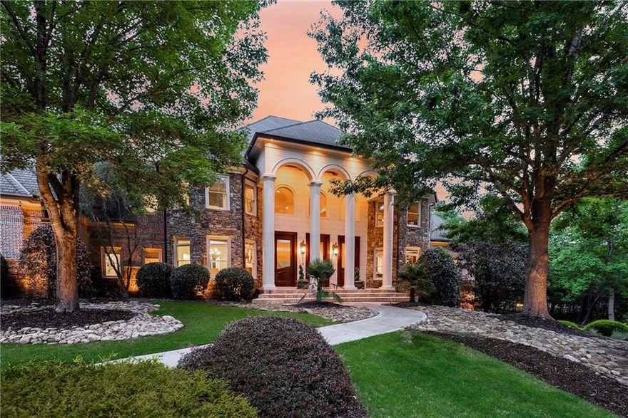 Tucked inside The Paddocks, a quiet enclave of luxury estates, 110 Ryan Lake Trail is a privately gated lakefront residence offering over 14,000 square feet of refined living space on 3.8 acres in Alpharetta—perfectly positioned on the Cherokee County side for the benefit of lower property taxes while remaining close to all that Milton and Alpharetta have to offer.
Designed for both grand entertaining and comfortable everyday living, this impressive privately gated residence features six bedrooms plus a large flex room currently used as a seventh bedroom, seven full bathrooms, three half bathrooms, and a total of six garage spaces. The home’s well-planned interior layout includes expansive living areas across all three levels, multiple bedroom suites, and a thoughtful blend of formal and casual spaces to suit a variety of lifestyles.
A grand two-story foyer with a timeless wrought-iron curved staircase opens to a spacious great room with soaring ceilings and a fireplace, creating a central gathering space for the home. The kitchen is designed for entertaining, with a large center island, Thermador and SubZero appliances, walk-in pantry, and a separate catering kitchen with private garage access—ideal for hosting events or large parties. The layout flows into a fireside keeping room and breakfast area, as well as a summer kitchen and living space with vaulted tongue-and-groove ceiling, grilling station, and dual dishwashers for convenient indoor-outdoor living. 
The main-level primary suite offers a private retreat with a morning bar, fireside sitting area, private balcony, spa-inspired bathroom, and an oversized custom walk-in closet with central island. The main level also includes a formal study, formal dining room, mudroom with built-ins, two guest powder rooms, and sizable laundry room.
Upstairs, a second primary suite with Juliet balcony is accompanied by two additional ensuite bedrooms, a fourth bedroom with hall bath, secondary laundry room, and a large bonus room that can serve as a playroom, media room, or seventh bedroom.
The finished terrace level is designed for recreation and relaxation, featuring a home theater, game room, sauna, custom fitness gym and golf simulator, full bar, wine cellar, guest ensuite, and an additional bathroom. It opens directly to the backyard and the property’s private lake frontage, offering a peaceful setting for quiet outdoor enjoyment. Additional highlights include a whole-home audio system, Vantage lighting controls, LeafGuard gutters, and a dedicated sump system. The grounds are professionally landscaped and include a full sprinkler system and outdoor lighting throughout. With four garages on the main level and two on the terrace level, the property is well-suited for car collectors, multigenerational living, or extra storage.
The private lake offers a unique and serene outdoor amenity for non-motorized recreation or simply enjoying nature. Zoned for sought-after Creekview High School and minutes from top local attractions, the home is just 5 minutes to Milton’s Mini Publix, 7 Acre Barn Grill, and Scottsdale Farms, 15 minutes to the shops and restaurants of Downtown Crabapple, and 20 minutes to GA-400, Avalon, and Halcyon. Additional 3 acres available for $650,000