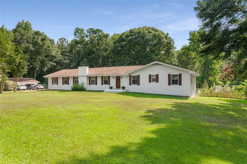 Enjoy peaceful country living just minutes from downtown Fayetteville. This 3-bed, 2-bath brick ranch sits on 5 private, gated acres with a freshly painted exterior, detached 2-car garage, and full unfinished basement. The fenced backyard features a saltwater pool, oversized screened-in patio, garden space, and a large chicken coop—perfect for anyone looking to start a small homestead. Additionally there are peach trees, a persimmon tree and muscadine vines on the property!
Inside, the living room offers a cozy brick fireplace and flows into a spacious kitchen with ample cabinet storage. There’s also a separate dining room, a flex space off the entry, and a small private office—ideal for remote work or hobbies. Under 30 minutes to the airport this home offers the space, privacy, and potential to truly make it your own.