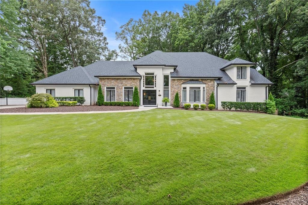 Discover this beautifully renovated custom estate, perfectly situated on one of Brookfield’s most coveted lots. Overlooking the 9th hole, the home offers sweeping year-round views of the lake and golf course, all from a quiet cul-de-sac setting. The level lot provides direct access to the cart path and is just steps away from the clubhouse—ideal for both everyday living and entertaining.
Inside, refined updates and designer finishes create a seamless blend of luxury and comfort. With 5 bedrooms and 5.5 baths, the open floor plan is anchored by a dramatic two-story foyer. A formal dining room and private office with French doors frame the entrance, while the fireside living room opens directly to the covered patio, complete with fireplace, bar, TV, and heater for true indoor-outdoor living.
The chef’s kitchen is the heart of the home, featuring professional-grade appliances, custom cabinetry, a butler’s pantry with wine storage, an oversized island, and a casual dining space with panoramic views of the course. A spacious garage accommodates two vehicles plus a golf cart, and connects directly to a mudroom, laundry center, and walk-in pantry for everyday convenience.
The main-level primary suite is a private retreat, offering a sitting area with fireplace, tray ceilings, remote-controlled shades, spa-inspired bath, and a fully customized walk-in closet. Upstairs, two or three additional bedrooms and an oversized walk-in attic/flex space provide ample storage or the option to finish into more living space.
The terrace level offers incredible versatility with a full in-law suite, complete with fireplace and bath, plus room for a recreation space, media room, office, or additional bedroom.
Living in Brookfield Country Club means access to a lifestyle second to none. Membership opportunities include a championship 18-hole golf course, brand-new fitness center, updated driving range, 10 tennis courts (six hard, four clay), resort-style pool, full-service restaurant, and year-round social events.
All of this in a prime Roswell location—minutes from downtown Roswell, Alpharetta, top-rated schools, and the best park system around.