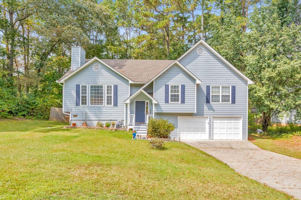 Welcome to this 4 bedroom, 3 bathroom home set on a private, wooded half-acre lot backing to Corps of Engineers property with scenic trails leading to Lake Allatoona. Step inside to a fireside family room with soaring vaulted ceilings, a separate dining room, and an updated kitchen featuring granite counters, a pantry, and abundant cabinet space. The primary suite offers tray ceilings, a spa-like bath with double vanities, a soaking tub, separate shower, and a walk-in closet. Two secondary bedrooms share a full bath, while the daylight basement provides a large bedroom with a sitting area, ensuite bath, and walk-out access—ideal for guests or an in-law suite. Enjoy outdoor living on the main-level deck or the covered terrace-level patio overlooking the spacious fenced backyard. An attached 2-car garage and a prime location near Downtown Acworth, I-75, shopping, dining, and Lake Allatoona make this home a perfect blend of comfort and convenience.