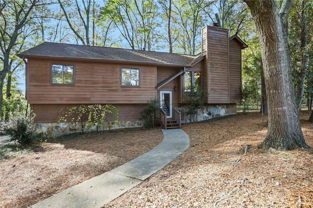 Welcome to this private retreat nestled in the woods. Secluded yet close to so many amenities. Walk into a wonderful entertaining space with a stone fireplace as the focal point. The space opens up to a dinning room and kitchen. Go out to the oversized deck and have a fun party with family and friends. The deck overlooks a large backyard with a dry creek and partial fencing. Primary bedroom with a walk in closet and private bathroom with a brand new shower. Two more bedrooms and a full bath on the same level. Downstairs can work for you any way that you see fit. Great space for an office, an inlaw suite or teen suite with a private entrance. Waiting for your personal touches. An over sized two car garage offers extra space for tools and storage. The house has recently had new LVP flooring, been pressured washed and the interior of the house has been painted and exterior trim has been painted. So convenient to shops, businesses and parks. A must see. Go and show!