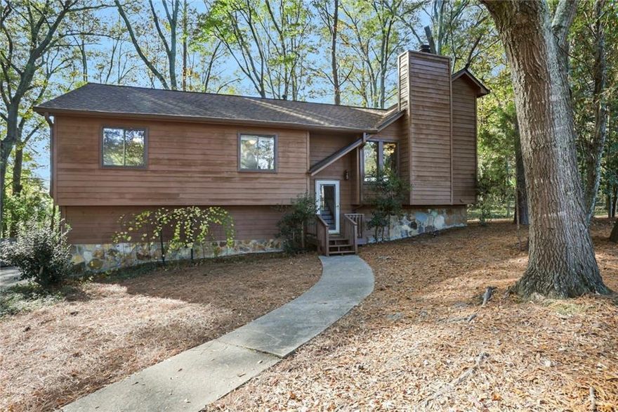 Welcome to this private retreat nestled in the woods. Secluded yet close to so many amenities. Walk into a wonderful entertaining space with a stone fireplace as the focal point. The space opens up to a dinning room and kitchen. Go out to the oversized deck and have a fun party with family and friends. The deck overlooks a large backyard with a dry creek and partial fencing. Primary bedroom with a walk in closet and private bathroom with a brand new shower. Two more bedrooms and a full bath on the same level. Downstairs can work for you any way that you see fit. Great space for an office, an inlaw suite or teen suite with a private entrance. Waiting for your personal touches.  An over sized two car garage offers extra space for tools and storage. The house has recently had new LVP flooring, been pressured washed and the interior of the house has been painted and exterior trim has been painted.   So convenient to shops, businesses and parks. A must see. Go and show!