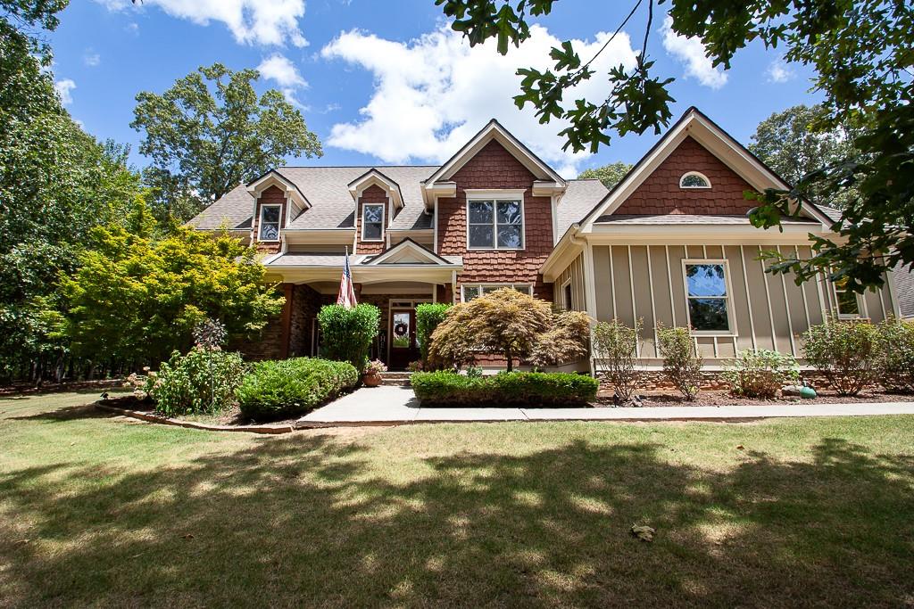 Beautiful craftsman home in the stately Branson Mill neighborhood nestled in highly sought-after north Cartersville! This executive home sits on a private 3-acre lot with a partially wooded backdrop. Watch the deer and listen to the wind in the trees while you swing on your spacious front porch or relax on your large, partially covered back deck with a stunning tongue and groove ceiling and Trex decking! The home has stone and shaker accents with board and batton in front! Hardiplank siding wraps the rest of the home to ensure long-term peace of mind. The great room features soaring ceilings, custom built-ins, a stone fireplace, and wall-to-wall windows to let in the sights of nature with all the natural light. The spacious kitchen boasts plenty of rich wood cabinets, granite countertops, and stainless-steel appliances. Take your pick of the two breakfast areas off the kitchen with one boasting a gorgeous, vaulted tongue and groove ceiling! Separate dining room with custom molding. The oversized master suite has tray ceilings, his and her closets, and a private door to the back deck. The large master bathroom contains a double vanity, soaking tub, separate shower, and large picture window. The home has rich hard wood floors in the living areas, with craftsman details sprinkled throughout. The upstairs offers three large bedrooms. One bedroom has its own private bathroom while the other two are joined by a full jack and jill bath. In addition to the attached two-car garage, the home also has a detached two-car garage with HVAC, custom work space, and a living quarters upstairs- ideal for an in-law/teen suite or office, already stubbed to easily add a bathroom in the future. The property neighbors the large, community saltwater pool and playground. Simply walk next door for swimming and recreation while still being totally secluded from the outside in your own private oasis. The roof is about 12 years old and the water heater is only three years old. Very low annual HOA and NO initiation fee!