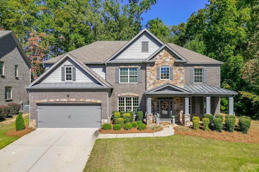Meticulously maintained 5-bedroom, 4-bath home located in the award-winning Buford City School District. Nestled on a stunning private lot, this home showcases beautiful custom trim, hardwood flooring on the main level and custom millwork features adding warmth and sophistication to every space. The open-concept floor plan offers endless options for everyday living and entertaining. The kitchen is a cook's dream, featuring top-notch appliances, double ovens, and abundant counter and cabinet space. A keeping room with a second fireplace provides a cozy retreat, while the butler's pantry and custom mudroom blend function with style. The living room boasts a stunning floor to ceiling window wall, beautiful stacked stone fireplace and custom benches and shelving.  The dining room is a true stunner with coffered ceiling, window box trim, crown molding & beautiful natural light.  Don't miss the bedroom on the main level for additional sleep space, home office or playroom.  Upstairs, the owner's suite is a true escape with a large sitting area and spa-inspired ensuite bath. There are 3 additional large bedrooms all with private access to a bathroom and the amazing laundry room with sink!! Outside, enjoy an entertainer's DREAM backyard complete with a covered patio, built-in Blackstone griddle and smoker, and plenty of space to gather. Conveniently located in the desirable Whispering Creeks community, within walking distance to Buford High School and the Buford Community Center, this home truly has it ALL!