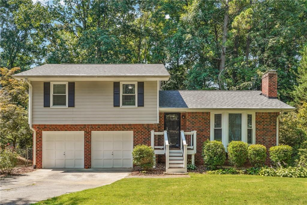 Charming Renovated Home Just Steps from Downtown Roswell! Enjoy walkability to Canton Street from this beautifully updated 3-bedroom, 2-bath split-level home tucked away on a quiet street with a spacious, landscaped lot. The inviting main level features vaulted ceilings, a wood-burning fireplace, and all-new hardwood floors that flow into the refreshed kitchen with newly refaced cabinets, granite countertops, and stainless-steel appliances. The open-concept layout includes a light-filled dining area and an expansive sunroom with hardwood floors and panoramic views of the private backyard—perfect for relaxing or entertaining. Step outside to the newly expanded back deck and enjoy the peaceful outdoor setting. Upstairs, you’ll find three spacious bedrooms and two updated bathrooms. Major updates include a new roof, new front porch, encapsulated crawl space, new carpet, new hardwoods, and young windows and water heater. No rental restrictions and a preferred lender credit available—don’t miss this rare opportunity to live close to all that downtown Roswell has to offer!