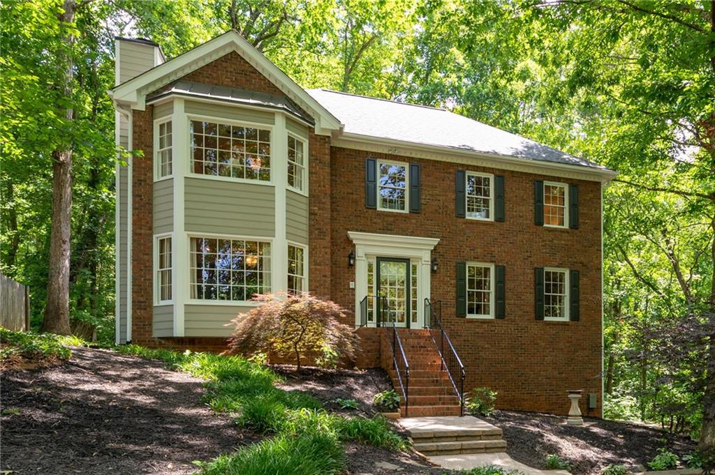 Stunning 4 bedroom / 2.5 bathroom meticulously maintained East Cobb home is situated on over .50 acre private homesite in highly sought after Lassiter High district. From new roof and new exterior paint to the hardwood floors throughout this beautiful home it is perfect in every way. As you enter 3841 Bluffview Drive the inviting foyer is flanked on the left by the spacious great room with brick fireplace and detailed millwork throughout this space; on the right by the large living room that can easily be used as a music room, home office or a flex room; from the great room or separate formal dining room you enter the chef's kitchen featuring white cabinetry, granite counters; tiled backsplash, eat-in kitchen, work station, updated appliances, and island with cooktop; ample size laundry room and half bath complete this main level living area; the upper floor features a massive primary bedroom with fireplace, trey ceiling and bay window sitting area; the spa-like primary bathroom boasts whirlpool tub, separate shower and double vanity; 3 additional large secondary bedrooms and full bath complete this upper level living area; the lower level basement area features a finished flex room that can be a second family room, home office, theater room, workout room or playroom; the lower level also has a large 2-car garage with extra deep storage area for golf cart, workshop, motorcycles and etc.; the huge rear deck overlooks the very private backyard and plenty of space for entertaining; the park-like backyard has pathways and stairs to access the lower level to make use of this incredible property.