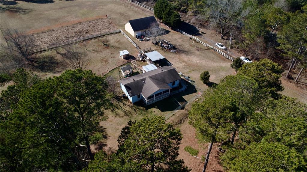 Welcome to this charming ranch home set on a generous 3.4-acre lot in the up-and-coming Dacula area! Enjoy privacy from all sides with plenty of open land—perfect for owning animals, farming, or simply spreading out and enjoying the space. The main level offers 2 bedrooms that share an oversized bathroom with a separate tub and shower. A bright kitchen and dining area bring in tons of natural light, creating a warm and inviting feel. The unfinished basement provides room to grow, with space to add 2 additional bedrooms, a bathroom, and a family room. Out back, a 6-car garage/workshop gives you even more room for storage, hobbies, or workspace. Whether you're looking for a peaceful retreat, a mini farm, or a fresh start in a growing community, this property has so much potential. Conveniently located near Hwy 316 and downtown Dacula—don’t miss this opportunity!