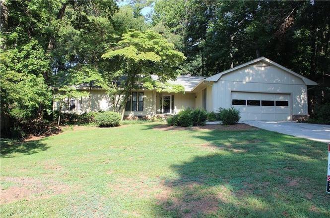 RARE OPPORTUNITY FOR ONE LEVEL LIVING in award winning WALTON school district and sought after Indian Hills! Well maintained with rocking chair front porch. Hardwood floors on main. Floor to ceiling Brick fireplace in living room. 2 car garage, separate laundry room. HUGE, EAT IN KITCHEN. Spacious guest rooms and owner's suite. Screened in Porch overlooks beautiful green, PRIVATE BACKYARD. Close to 1/2 Acre lot, majestically sits on one of East Cobb's most sought after streets in swim/tennis/golf Indian Hills!